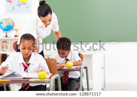 caring elementary school teacher and students in classroom