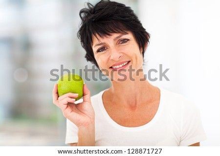 healthy mid age woman holding apple closeup