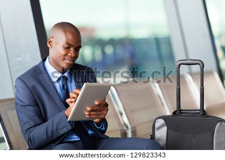 Black Businessman Using Tablet Computer At Airport