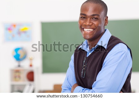 handsome male african primary school teacher in classroom