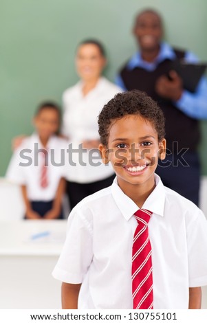 elementary school boy in front of teachers and classmate in classroom
