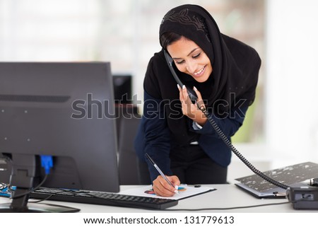 happy young middle eastern businesswoman working in office