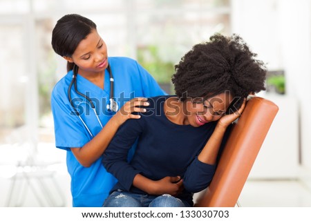 african female medical worker comforting a sick patient in hospital