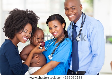 portrait of happy african pediatricians with mother and baby after checkup