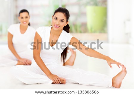 Beautiful young women doing stretching exercise - stock photo