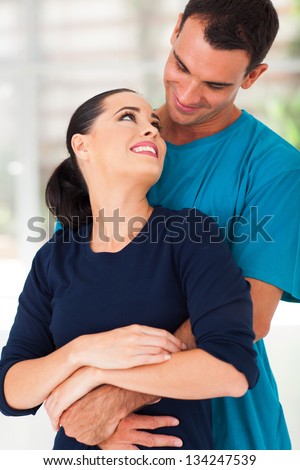 romantic young couple hugging at home