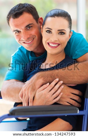 loving husband hugging handicapped wife at home