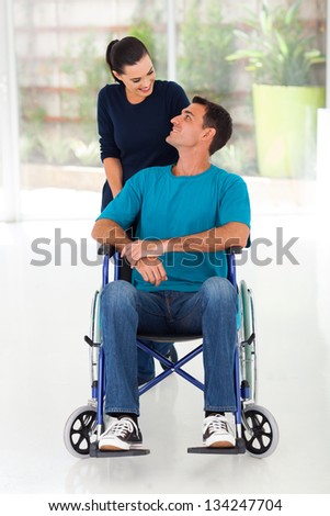 caring wife talking to disabled husband at home