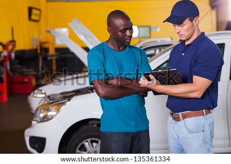 african man inside vehicle workshop with auto mechanic