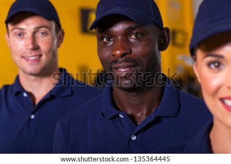 close up portrait of afro american auto technician with colleagues
