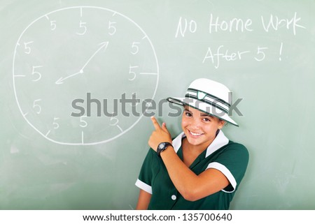 cheerful high school student pointing at the watch drawn on the chalkboard