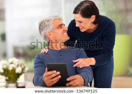 beautiful loving middle aged couple with tablet computer