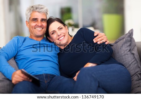 beautiful loving middle aged couple sitting on sofa