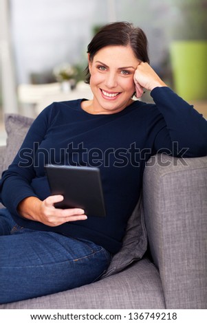 middle aged woman using tablet computer at home