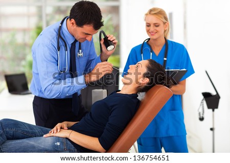 pretty woman having throat examination in doctor\'s office