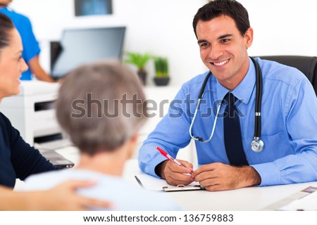 medical doctor consulting senior patient in office