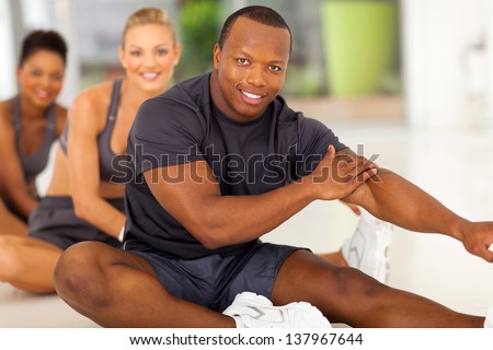 happy african man with team stretching before exercise