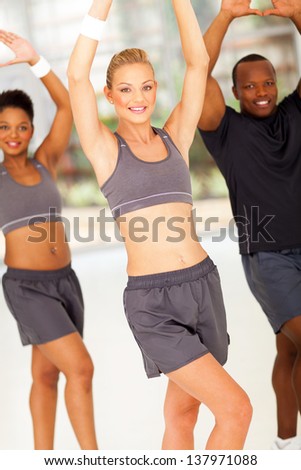 beautiful young woman exercising with friends