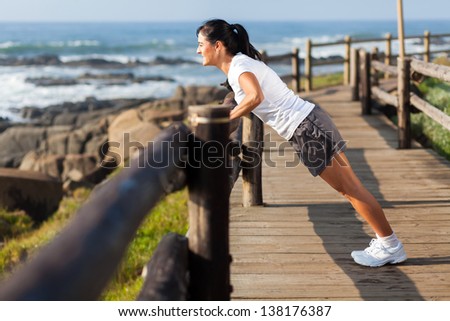 fit middle aged woman exercising at beach in the morning