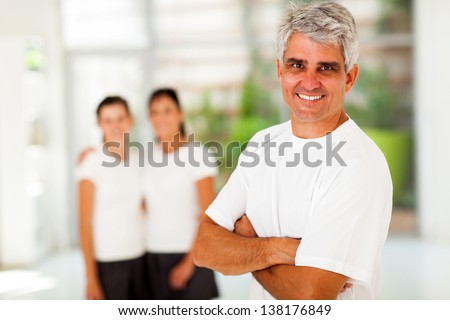 sporty mature man in front of his family at home gym
