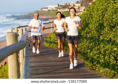 active family running by the beach in the morning