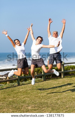 active family jumping at the beach