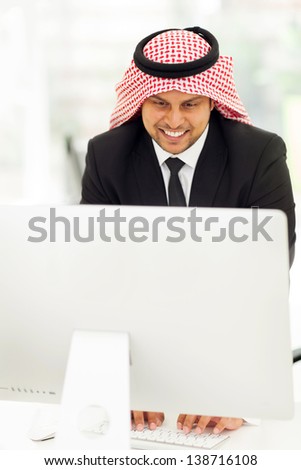happy middle eastern businessman working on the computer