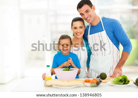 adorable young family cooking in kitchen at home