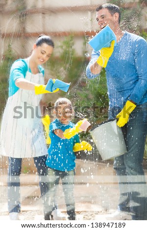 happy young family cleaning home window glass
