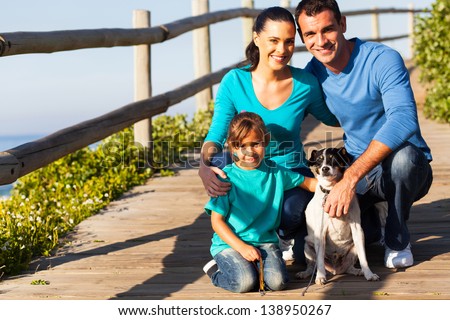 happy young family with pet dog at the beach