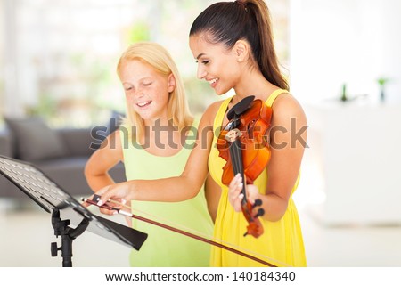 pretty music teacher pointing notes to her student
