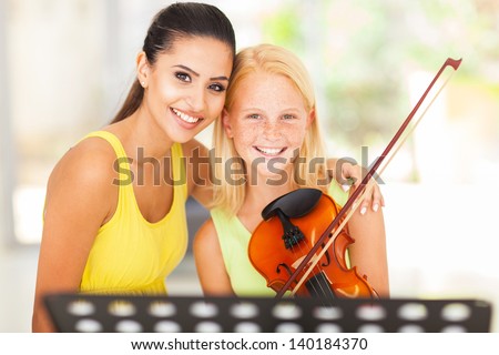 beautiful music teacher with young violin student