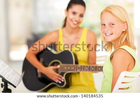 happy pre teen girl in music class with teacher