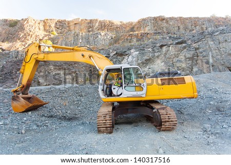 mine worker operating excavator on mining site