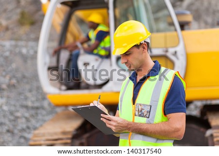 construction manager writing report at construction site