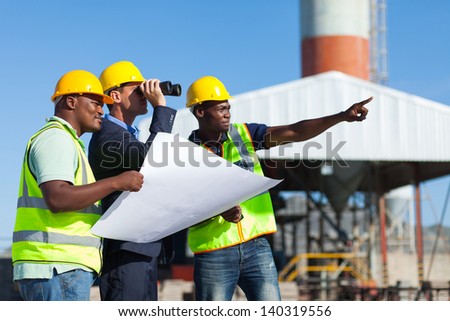 Project Manager Visiting Construction Site With Construction Workers
