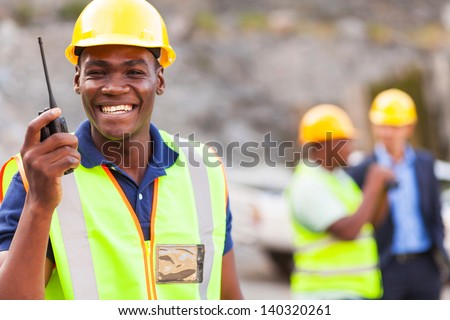 cheerful afro american mine worker with walkie talkie
