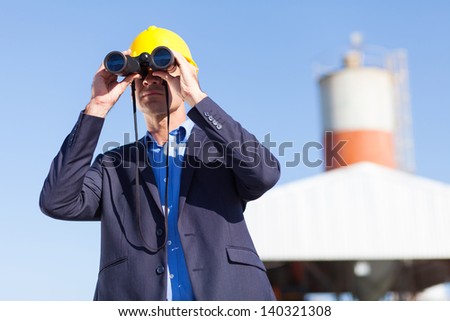 industrial manager with binoculars outdoors