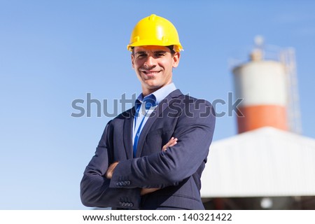 male industrial engineer in mining site with arms crossed
