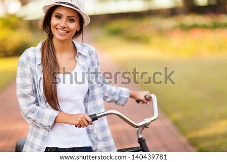 happy young woman riding her bike outdoors at the park