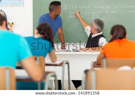 senior high school biology teacher teaching students in classroom