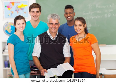 group of cheerful high school students in classroom with senior teacher