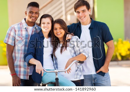 group of happy high school students with a bicycle outdoors