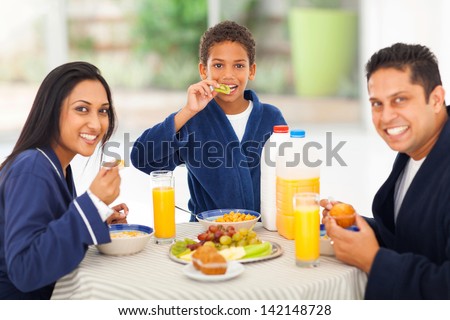 cheerful cute indian family enjoying their breakfast together