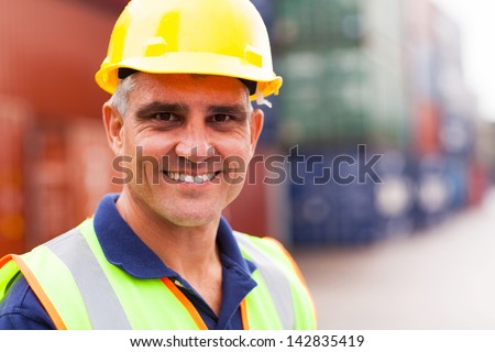 happy senior harbor worker at container depot