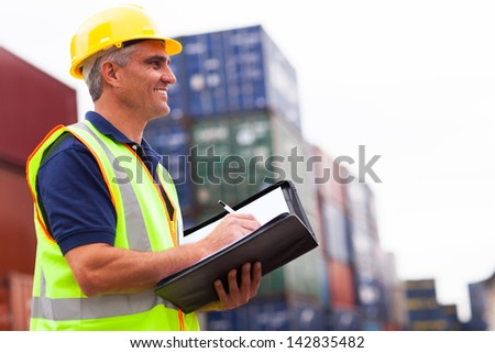 smiling middle aged harbor worker at container depot