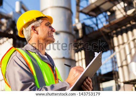 mid age petroleum factory worker working outdoors