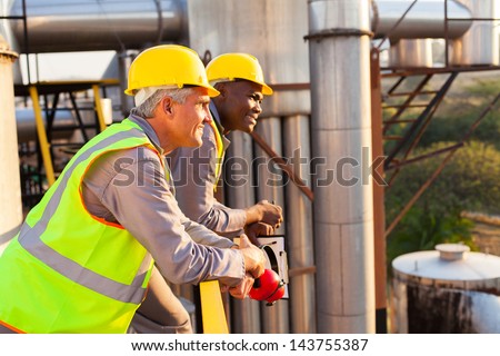 smiling industrial workers in safety gear