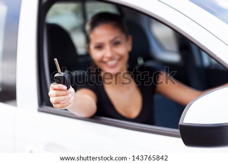 pretty woman showing car key inside new vehicle