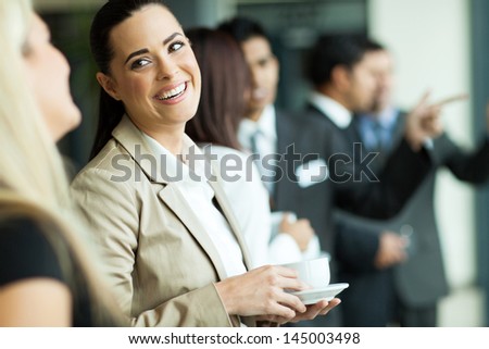 attractive businesswoman having fun conversation with colleague during break